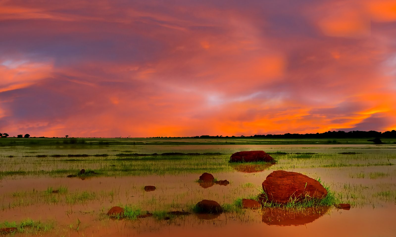 A vivid orange and pink sunset over the Jur River wetlands in South Sudan